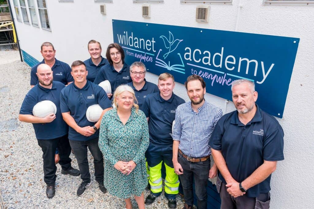Apprentices from Wildanet join senior members of staff and the College for a group photo outside the new 'Wildanet Academy' building.