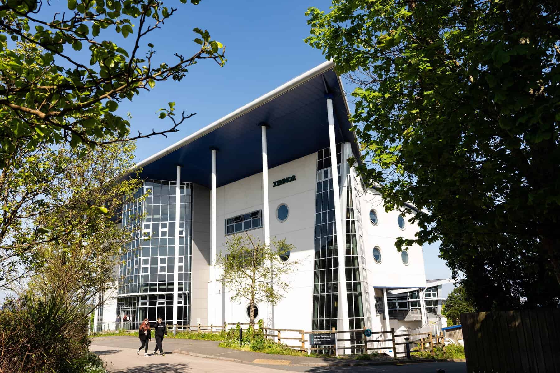 Penwith Campus 026 A photo of the front of the Zennor building at Penwith College. It is a sunny day and there are students walking in front of the building.