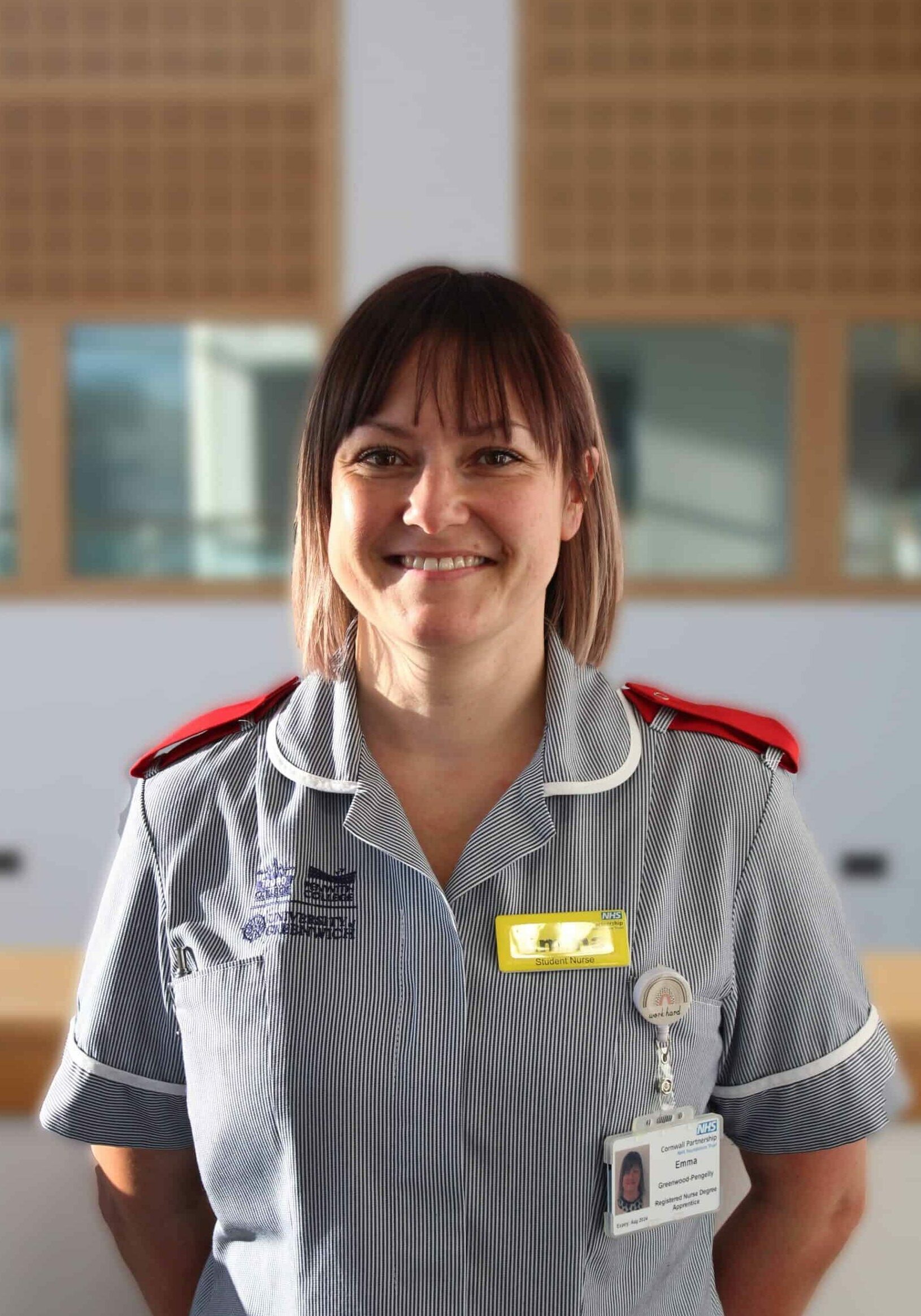 Student Emma stands in her Nurse's uniform with her hands behind her back.